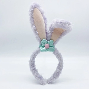 Close-up of light purple plush rabbit ear headband with mint green fabric floral detail