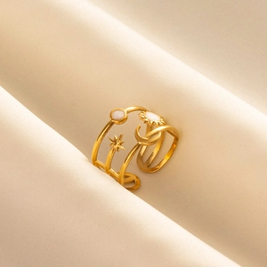 Close-up of triple-layered gold spiral ring with celestial sun, moon, and star motifs
