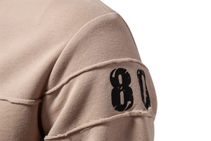 Detailed macro view of khaki knitted sweatshirt showing shoulder seams and number 80 print