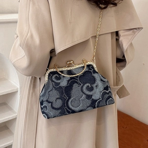 Denim handbag with cloud print, gold rhinestone frame, and chain strap on model
