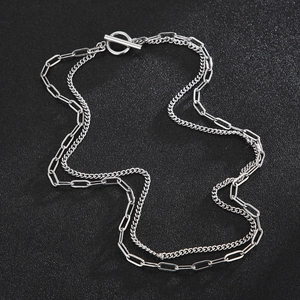 Double-layered silver titanium necklace with OT buckle and cuban link chain on black texture
