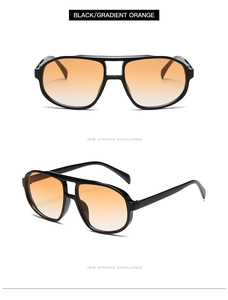 Close-up of black aviator sunglasses with gradient orange lenses and dual bridge detail