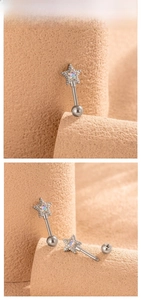 Close-up of star shaped cartilage piercing made of titanium steel with AB crystal inlay