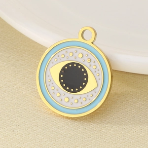 Macro detail of gold stainless steel Evil Eye pendant with blue and white enamel inlay