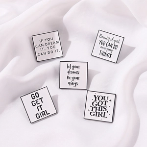 Set mit fünf quadratischen Emaille-Pins mit Motivationssprüchen auf Seidenstoff