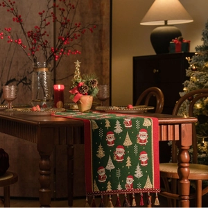 Close-up of green Christmas table runner with festive jacquard patterns and tassels