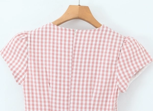 Vue détaillée du dos d'une mini-robe à carreaux rose et blanc avec manches bouffantes