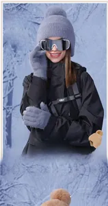 Close-up of grey plush winter hat with faux fur pompom and matching gloves for women