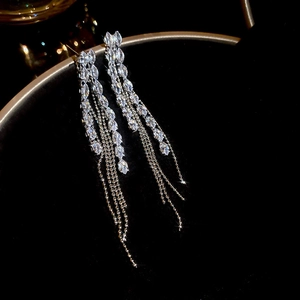 Close-up of sparkling marquise-cut crystal tassels and silver needle chain earrings