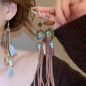 Detail of bohemian tassel earrings with turquoise beads, wood rings and blue fringe