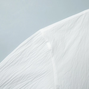 Detailed macro view showing the pleated texture and fine stitching on white fabric