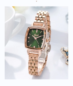Detail of rose gold square watch with green dial and rhinestone accents on table