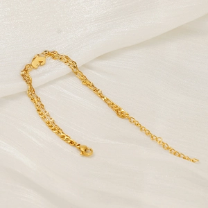 Gold stainless steel double layer chain bracelet with heart pendant on white fabric