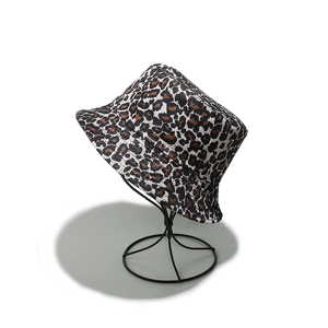 Detailed view of leopard print bucket hat with wide brim on black metal display stand