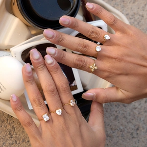 Detailed view of adjustable gold chain rings with various shaped zirconia stones for women
