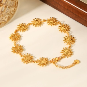 Detailed macro view of 18K gold-plated stainless steel sun charm anklet with lobster clasp