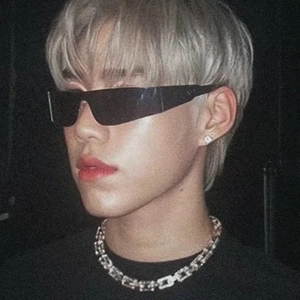 Close-up of futuristic rimless black sunglasses and silver chunky G-link chain necklace