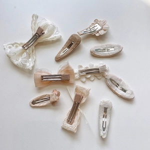 Detail showing the metal duckbill clips and snap base of 9-piece fabric hair clips
