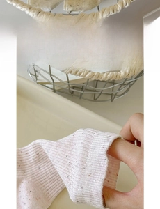 Close-up of flexible wide elastic cuff on pink flecked cotton blend knit socks