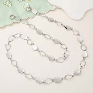 Detailed macro view of silver metallic chain strap with lobster clasp on beige background