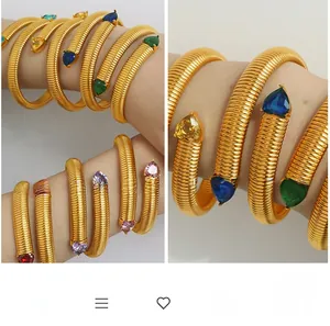 Detailed shot of golden spiral snake bracelet with multi-color heart gemstones on wrist