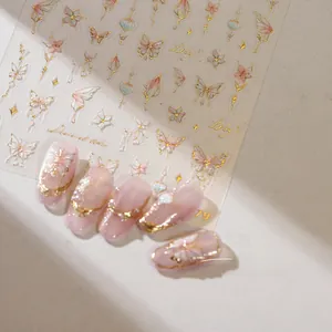 Detailed view of pink and gold butterfly nail art stickers with elegant floral motifs