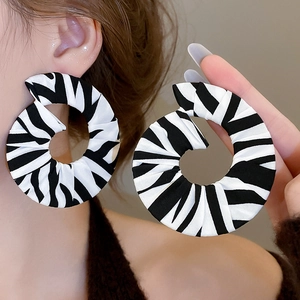 Close-up of zebra pattern fabric spiral earrings with unique black and white texture