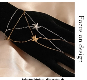 Detailed close-up of gold and silver starfish hand chains with finger ring attachment