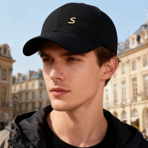 Men's black baseball cap with golden S Sports embroidery in an outdoor street setting