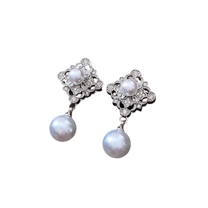 Elegant diamond-shaped hollow earrings with pearls and cubic zirconia on white background