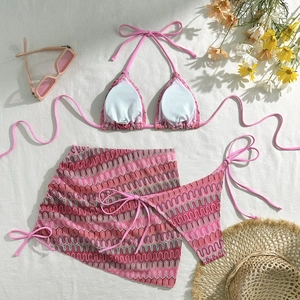 Détail à plat d'un ensemble bikini trois pièces brodé avec motif zigzag rose et paréo assorti