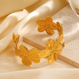 Bracciale a fascia regolabile a fiore dorato con trama in metallo spazzolato e fiori