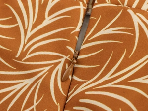 Detailed close-up of brown tropical leaf print fabric with a matching invisible zipper