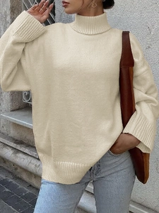 Dettaglio del maglione beige a collo alto in maglia con trama morbida e vestibilità ampia