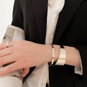 Polished silver irregular open bangle and ring set styled on a modern business suit