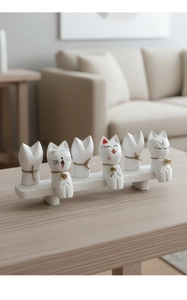 Macro view of six cute resin kittens with golden bells on a minimalist white base