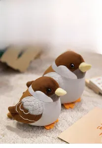 Close-up of two cute plush sparrow dolls in different sizes on a soft beige carpet