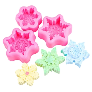 3D snowflake silicone molds with colorful finished scented candles on white background