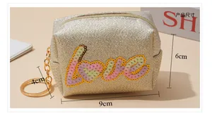 Detailed view of gold sequin Love coin purse measuring 9cm by 6cm by 4cm with keychain