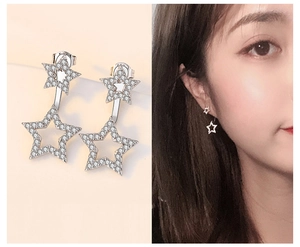 Detailed view of sterling silver star earrings with pave cubic zirconia on model