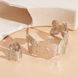 Detail of silver hollow butterfly cuff bracelet and ring set on minimalist stone