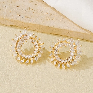 Detail of leaf wreath earrings with marquise-cut zircons and gold-plated copper finish