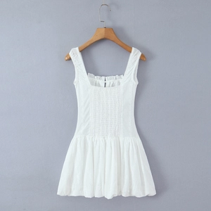 Detail showing white embroidered fabric and pleated chest design on the strap dress