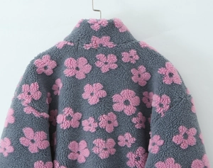 Close-up of fleece pullover collar with pink floral pattern on grey fabric texture