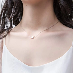 Close-up of polished S925 sterling silver bird pendant necklace worn on a female model