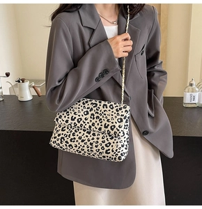 Detail of black and white leopard print fabric shoulder bag with gold chain strap