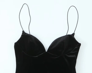 Macro detail of high-quality black velvet fabric with delicate thin shoulder straps