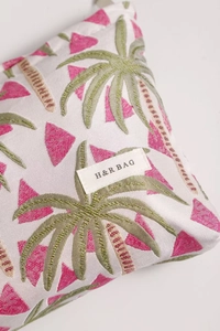 Close-up of jacquard fabric with palm tree embroidery and H&R BAG woven label detail