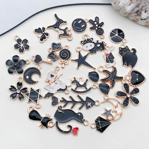 Macro shot of black enamel DIY alloy pendants in various shapes with gold border details
