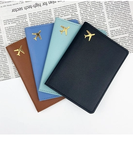 Close-up of faux leather passport holders with gold airplane logo in four various colors